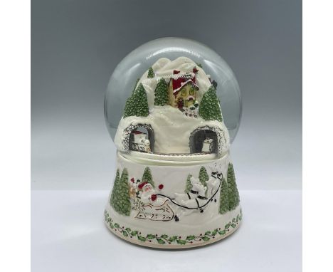 Beautiful sparkly winter scene in the snow globe of a train entering and leaving a snowy tunnel. The base depicts Santa and h