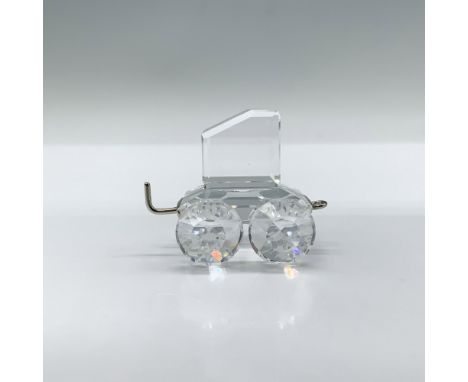 A clear faceted figure of a carriage with a metal hook and opening. Part of the Swarovski Crystal Express train and When We W