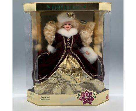 Dressed in a burgundy and gold-colored winter gown and head piece with faux fur. Fourth in the Holiday Barbie series in colla