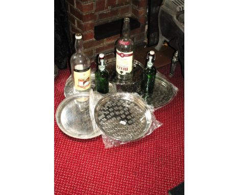 AN ASSORTMENT OF STAINLESS STEEL TRAYS, TWO LARGE GLASS WHISKEY BOTTLES AND TWO LARGE GROLSCH BOTTLES 