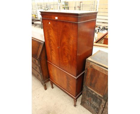 A MAHOGANY COCKTAIL CABINET WITH INLAID OVALS TO DOORS, DRINKS SECTION WITH PULL OUT SLIDE AND CUPBOARDS TO BASE ON TAPERING 