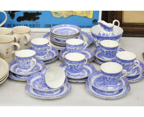 A QUANTITY OF ANTIQUE BLUE WILLOW WITH GOLD TRIM TO INCLUDE SLOP BOWL, MILK JUG, CUPS, SAUCERS, SIDE PLATES, CAKE/BREAD AND B