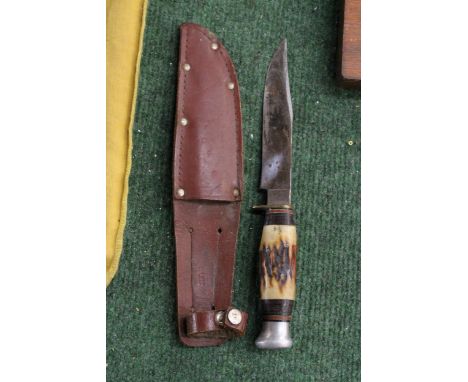 A VINTAGE HUNTING KNIFE IN A LEATHER SHEATH 