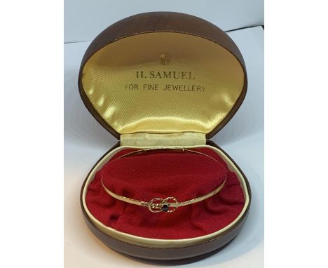 A 9 CARAT GOLD BANGLE WITH BLUE STONE GROSS WEIGHT 4.9 GRAMS IN A PRESENTATION BOX 