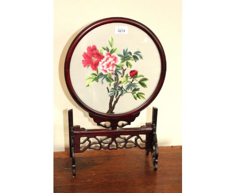 A SMALL CIRCULAR ORIENTL STYLE HARDWOOD SCREEN WITH SILK TAPESTRY OF FLOWERS 