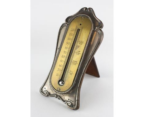An Art Nouveau silver-mounted brass thermometer, hallmarked Birmingham, 1904, William Hutton &amp; Sons, 16 cm high 