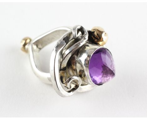 A large white metal ring of abstract design principally set with a faceted cut amethyst . No hallmarks - testing indicates si