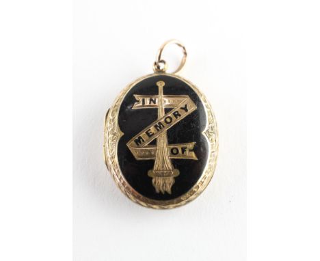 A yellow metal oval memorial picture locket with black enamel design. No hallmark - tests indicate gold of approximately 9ct 