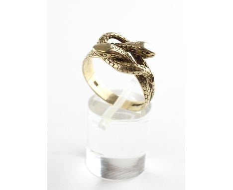 A yellow metal ring in the design of interlocking snakes. Hallmarked 9ct gold. Size R 4.5 grams