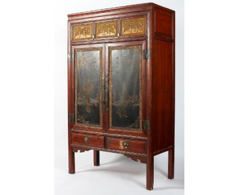 A large Chinese wedding armoire, the upper fall front door carved with gilt with chinoiserie figures, above two black lacquer