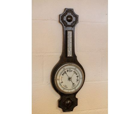 An oak cased banjo shaped barometer, early 20th century, with circular white dial above fahrenheit/centigrade gauge, below a 