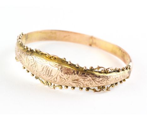 A yellow metal hollow half hoop bangle with bead edge and foliate engraving together with personal inscription. Hallmarked 9c