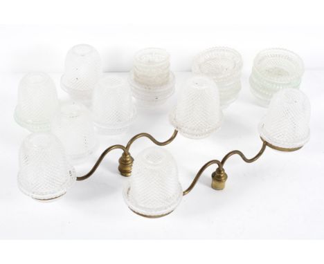A collection of glass cricklites, in three sizes including eight deep bowls and fifteen dishes; together with a pair of brass