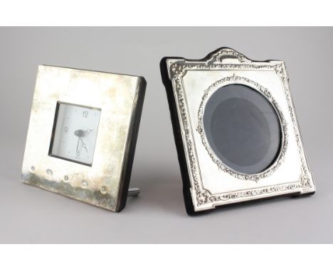 A modern silver photo frame of square form with embossed floral decoration, together with a modern silver clock - 12 cm x 12 