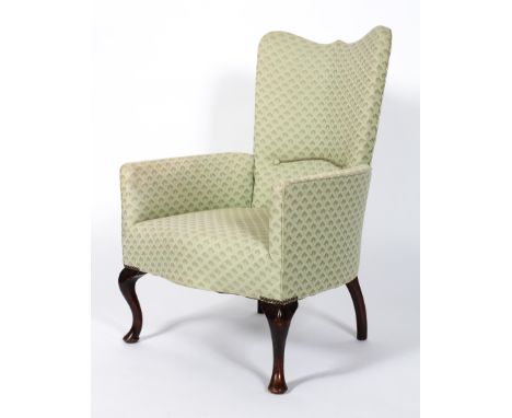 An armchair upholstered in pale green Art Deco patterned fabric, with wave-shaped top rail and serpentine seat, on George III