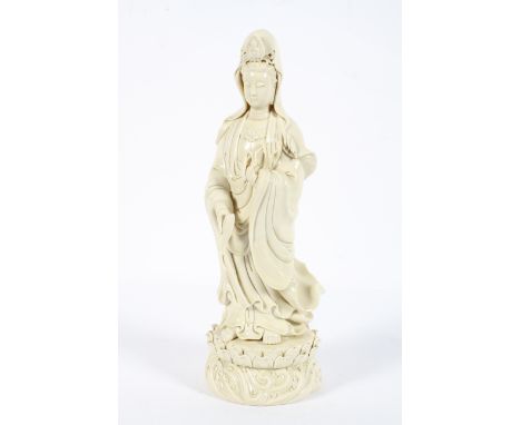 A Chinese blanc de chine figure of a Guanyin, 20th century, impressed seal mark to reverse, modelled standing holding attribu