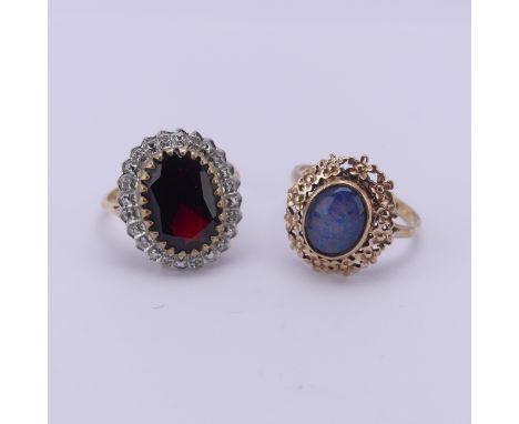 A garnet and diamond Dress Ring, the oval facetted garnet approx. 14mm long, within a white gold surround set diamond points,