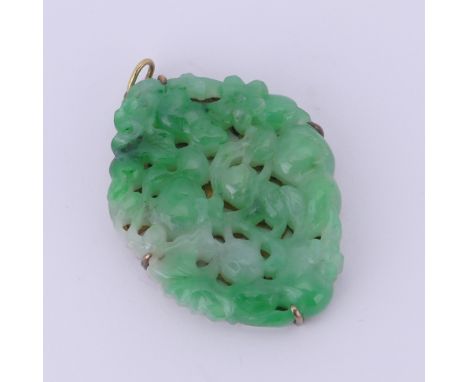 A Chinese Jade Pendant, carved and pierced with a rodent amongst foliage and flowers, unmarked yellow metal mount assessed as