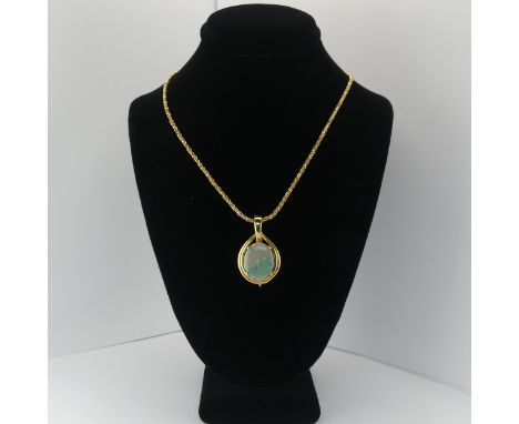 An Opal and diamond Pendant, the oval cabochon opal 16mm x 13mm four claw set with three diamond accents below, mounted in 18