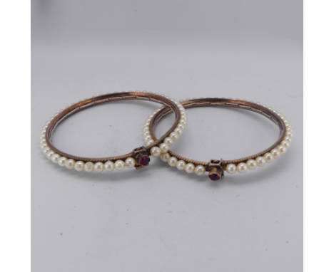 A pair of vintage Bracelets, probably Indian, decorated with faux pearls, the clasps each set ruby and marked 'CJJ', assessed