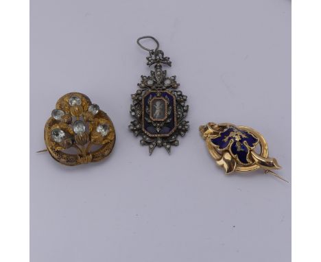 An antique 9ct gold Pendant / Brooch, of open scrolling form with blue enamelled foliate centre, 4cm long, 4.2g, together wit