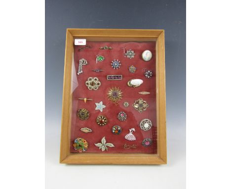 A framed display of vintage brooches