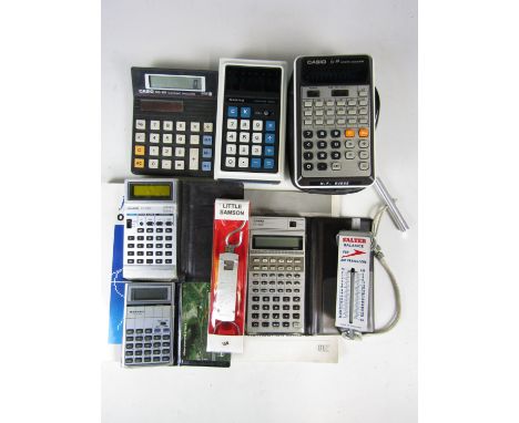 A quantity of vintage digital calculators and a 1960's travelling spring balance