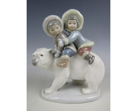 A Lladro figurine of two Eskimo children riding a polar bear