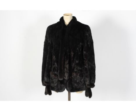 A ladies vintage black fur jacket. Having a neck tie, pockets and clip fastenings. Lined in brown fabric, L75cm x chest W46cm