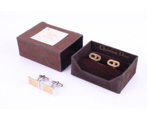 Two pairs of Christian Dior cufflinks. Comprising a gold plated pair designed to replicate the brand initials, in an original