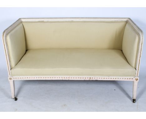 A late 19th Century French sofa, carved and painted frame. Carved sabre legs terminating with brass casters, upholstered in a