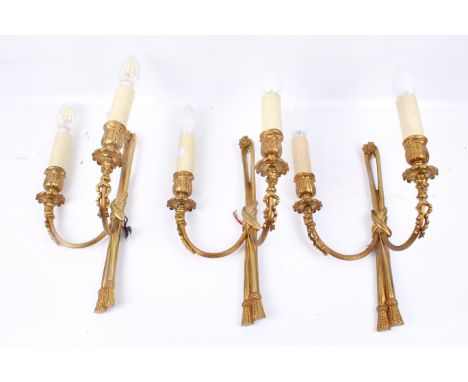 A set of three gilt metal wall light fittings with twin branches. H32cm