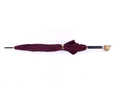 A Burberry fox head walking umbrella. Having a manual snap stud closure, gold tone fox head handle, black stick, end, stretch