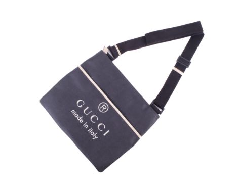 A Gucci black shoulder bag. Having an adjustable fabric strap with cream leather trim and plastic fastenings, the front pocke