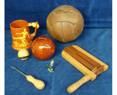 Football, a vintage, laced, leather football with lacing tool, a wooden football rattle, a metal footballing figure with leve