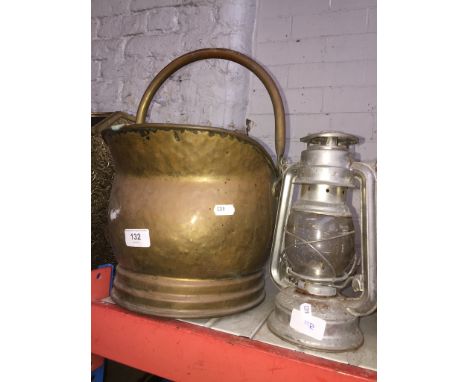 A brass coal bucket and Tilley lamp 
