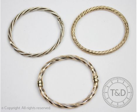 A 9ct yellow gold hinged bangle, of rope twist design, weight 14.1gms, with a 9ct gold bi-colour bangle of similar design, we
