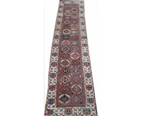 A Caucasian Kazak style hand woven wool runner, worked with with a panel of thirty two geometric gulls, 405cm x 87cm 
