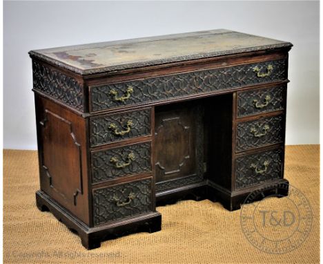 A George III and later carved mahogany architects desk, with two way ratcheted top, leather inset with a foliate carved edge,