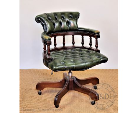A stained wood office swivel desk chair, with button back green leather upholstery, 86cm H CONDITION REPORT: General light ag