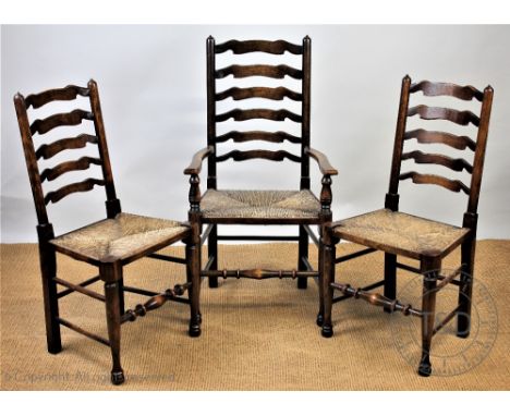 A set of eight stained beech ladder back dining chairs, including two with arms, with rush seats, on turned legs and pad feet