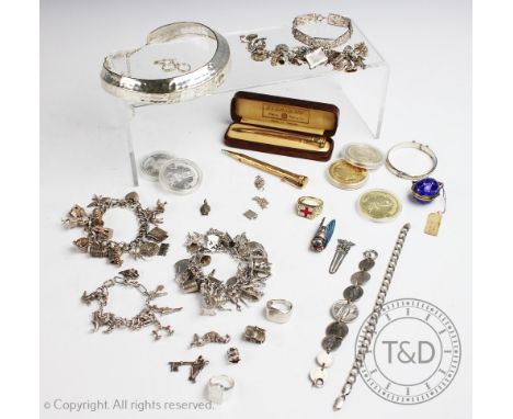 A collection of four silver coloured and silver charm bracelets, hung with numerous charms, with assorted rings, crowns, an E