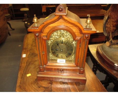 19th Century Continental walnut arched top mantel clock, the gilded dial with Roman numerals and a two train striking movemen
