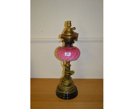 Brass oil lamp with pink glass well adapted for use with electricity