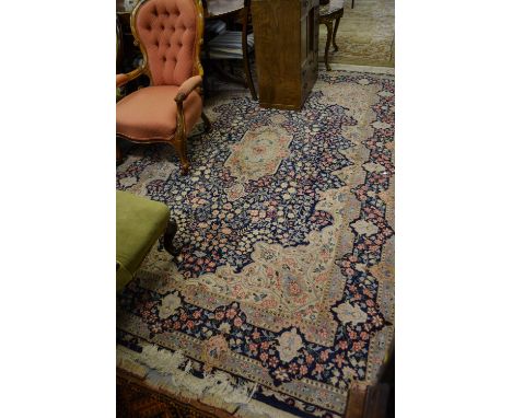 Small Kirman carpet with a medallion and all-over floral design on a blue ground with borders, approximately 9ft x 6ft
