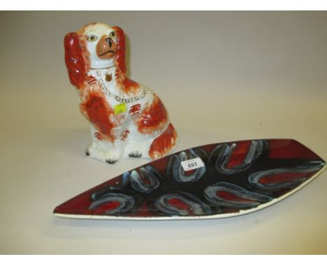 Poole pottery dish with stylised pattern on red and slate grey ground, together with a 19th Century Staffordshire dog