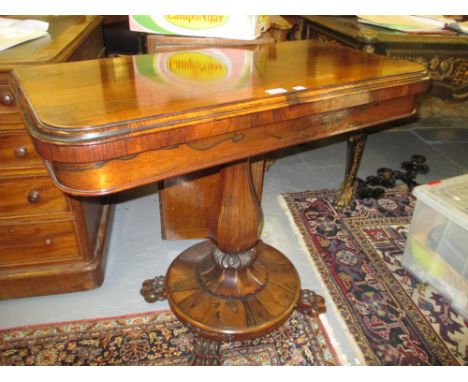 William IV rectangular rosewood fold-over card table on tapering hexagonal column, circular base, raised on carved lions paw 