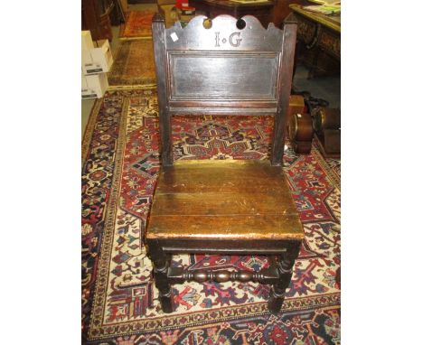 17th Century oak side chair, the rectangular panelled back with shaped surmount carved with the initials I.G., the plank seat