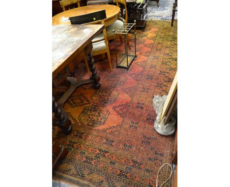 Large Afghan carpet with three rows of nine gols on a red and gold ground (some wear)