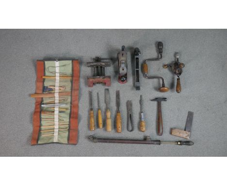 A collection of vintage tools, including a roll of carved pottery tools, various clamps and other tools. 